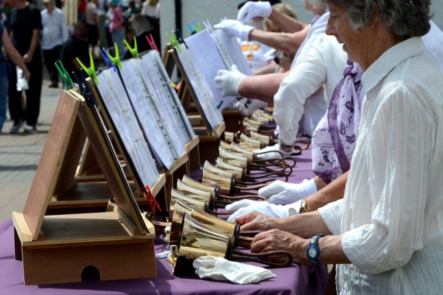 Dunkeswell Handbell Ringers performing outside St Paul's Church on Honiton Market Charter Day 2025