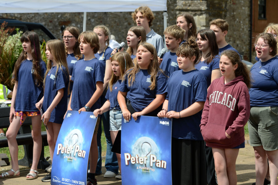 Members of Honiton Community Theatre Company performing outside St Paul's Church on Honiton Market Charter Day 2025